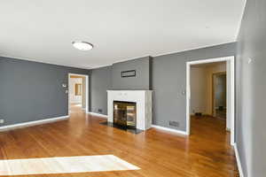 Living room with light wood flooring and a fireplace with hearth.
