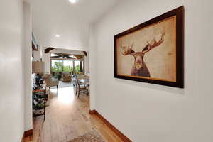 Hallway with light wood-style floors, recessed lighting, and beamed ceiling