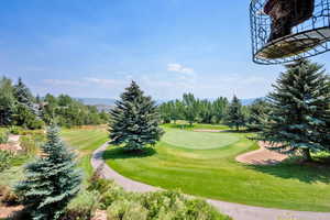 View of community featuring golf course view and view of wooded area