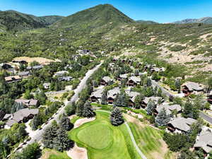 Aerial view of residential area with a mountain backdrop and a golf course