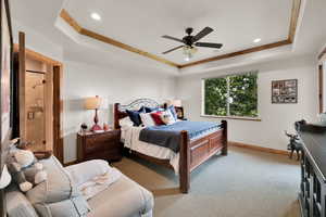 Bedroom with ornamental molding, a raised ceiling, carpet, recessed lighting, and a ceiling fan