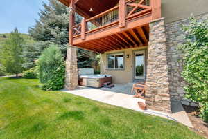 View of patio with a hot tub and a wooden deck