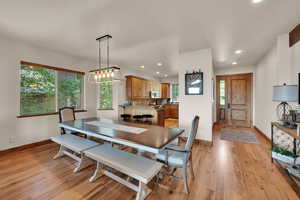 Dining room with light wood finished floors and recessed lighting