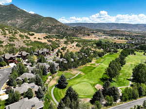 Aerial perspective of suburban area with mountains and a golf course