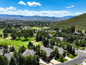 Aerial view of residential area with a mountain backdrop and a local golf course