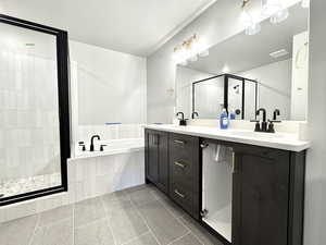 Full bathroom with a garden tub, a shower stall, double vanity, and tile patterned flooring