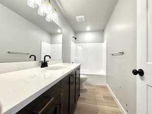 Bathroom featuring vanity, wood finished floors, and bathtub / shower combination