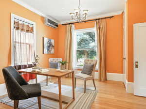 Office with light wood-type flooring, a chandelier, crown molding, and a split unit.