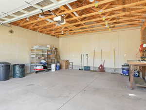 2-Car spacious garage with work bench and shelves.