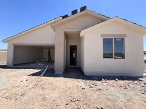View of front of home featuring stucco siding and an attached garage