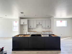 Kitchen with a center island, a textured ceiling, and light wood-style flooring