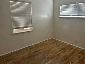 Unfurnished room featuring healthy amount of natural light and wood-type flooring