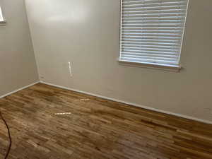 Unfurnished room with baseboards and wood-type flooring