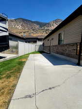 View of side of property featuring RV parking pad & a mountain view, brick siding, and a gate