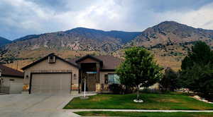Craftsman house with concrete driveway, a garage, a mountain view, and stone siding