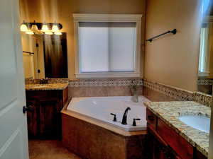 Master Bathroom featuring two vanities, deep soaking tub & separate shower