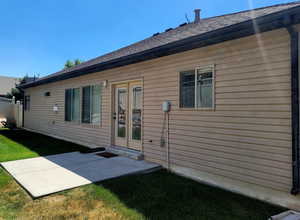 Rear view of property featuring roof with shingles, a patio with a gas stub for your bbq grill, and a yard