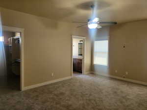 Master bedroom w/new carpet, spacious walk in closet, ensuite bath, and a ceiling fan
