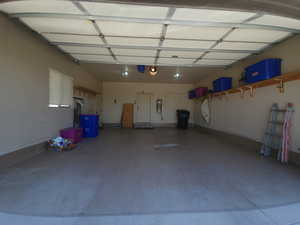 View of finished garage with epoxy coated flooring & storage shelving.
