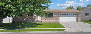 View of front facade with a garage, concrete driveway, and brick siding