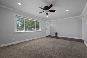Spare room with crown molding, dark carpet, a textured ceiling, recessed lighting, and a ceiling fan