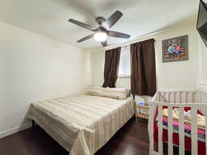 Bedroom with a textured ceiling, wood finished floors, and a ceiling fan