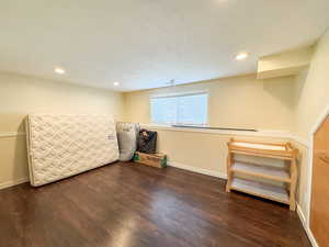 Basement featuring a textured ceiling, wood finished floors, and recessed lighting