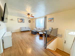 Spacious Living room featuring a textured ceiling, wood finished floors, and ceiling fan