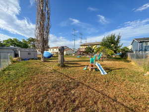 View of yard with a storage shed and a playground