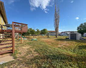 View of yard with a storage unit and a wooden deck