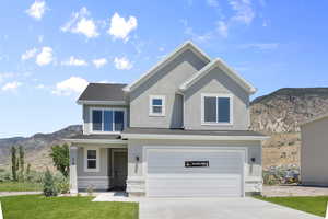 View of front of property featuring a mountain view, stone siding, a garage, driveway, and stucco siding