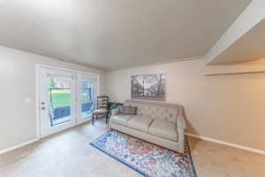 Living area featuring carpet flooring and a textured ceiling