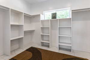 Spacious closet featuring light marble finish floors