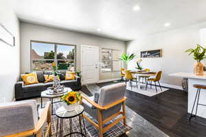 Living area featuring dark wood-type flooring and recessed lighting