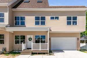 View of front of home featuring driveway, a shingled roof, an attached garage, and covered porch