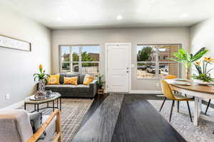 Living room featuring plenty of natural light, dark wood-type flooring, and recessed lighting