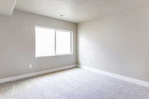 Spare room with a textured ceiling and carpet floors