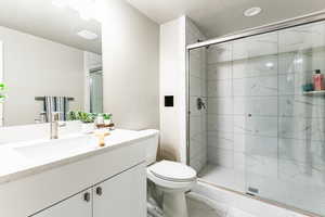 Bathroom featuring vanity, a marble finish shower, and marble finish flooring