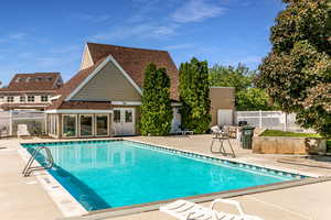 Community pool with a patio area and french doors