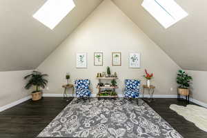Living area featuring a skylight, wood finished floors, and lofted ceiling