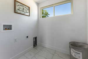 Laundry area with hookup for an electric dryer, light marble finish floors, and hookup for a washing machine