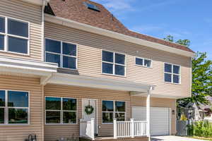 View of front of property featuring roof with shingles, an attached garage, and driveway