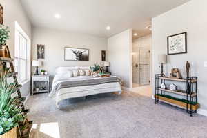 Bedroom featuring light carpet, recessed lighting, and connected bathroom