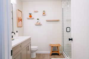 Full bathroom featuring vanity, a shower stall, and wood finished floors