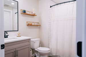 Full bath featuring vanity and toilet