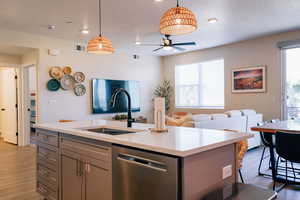 Kitchen with wood finished floors, stainless steel dishwasher, light countertops, gray cabinetry, and recessed lighting