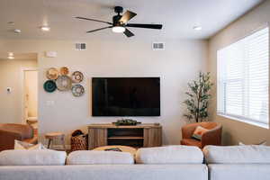Living room with ceiling fan, recessed lighting, and a textured ceiling