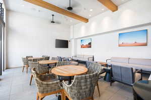 Dining room with beam ceiling, a towering ceiling, light tile patterned floors, ceiling fan, and recessed lighting