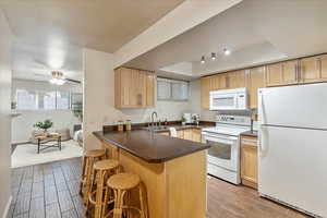 Kitchen with white appliances, light brown cabinets