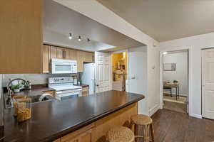 Kitchen featuring white appliances, and access to the laundry and utility room.